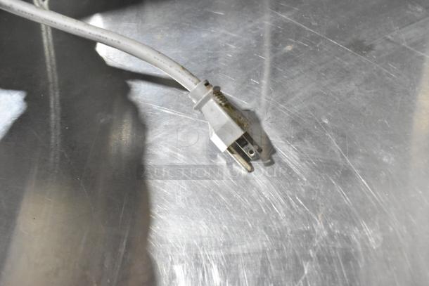 Close-up of an electrical plug on a metallic surface, part of the Turbo Air TUR-48SD commercial cooler, showcasing the power connection.