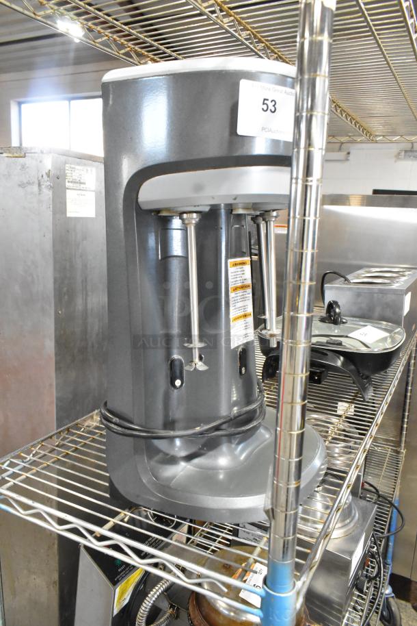 Hamilton Beach HMD400 commercial 3-head drink blender, metal finish, 120V, 1 phase, on a wire shelf in excellent condition.