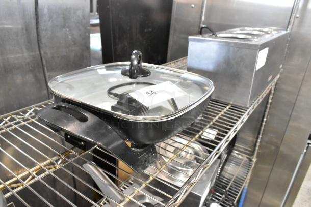 Farberware FW61100018857 electric skillet, metal design, glass lid, 120 volts. Appears in good condition with power cord.