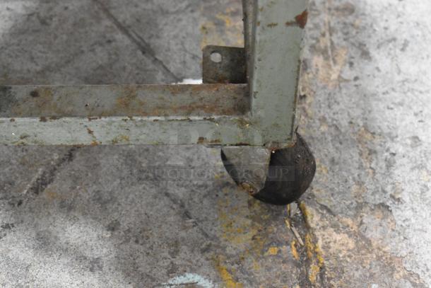 Lenin MQ077 tortilla machine with commercial casters. Visible signs of rust and wear. 110 volts, 1 phase.