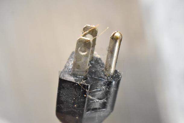 Close-up of an electrical plug for a Lenin MQ077 tortilla machine, showing some wear and dust. 110 volts, 1 phase.