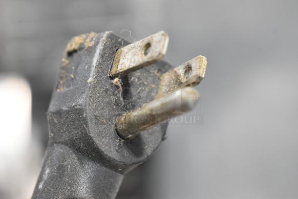 Close-up of a worn electrical plug for a Continental 1R-HD cooler, showing signs of dust and wear.