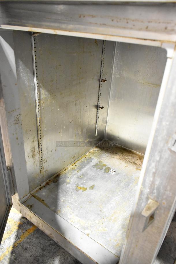 Continental 1R-HD stainless steel commercial cooler interior, showing wear and staining. Features include two half-size doors and commercial casters.