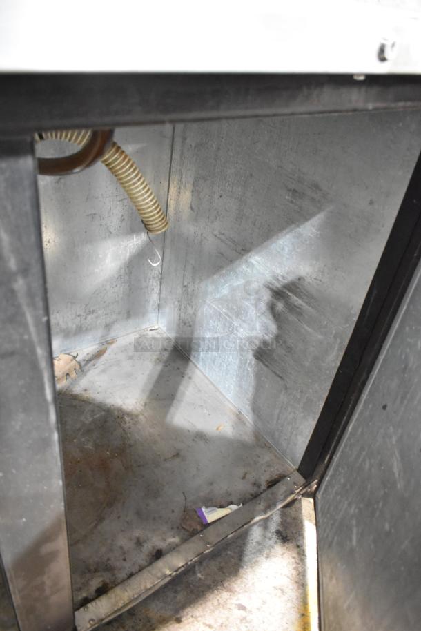 Micro Matic MDD-58 commercial kegerator interior view, showing metal surfaces and a coiled hose. Used condition.