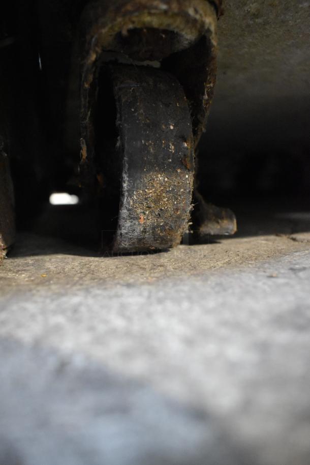 Rusted commercial casters of Continental 1RF-SS cooler/freezer unit, showing signs of wear and age.