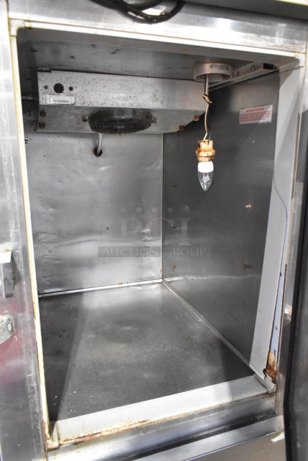 Continental 1RF-SS stainless steel commercial cooler/freezer interior. Visible shelving bars and light fixture; moderate wear.