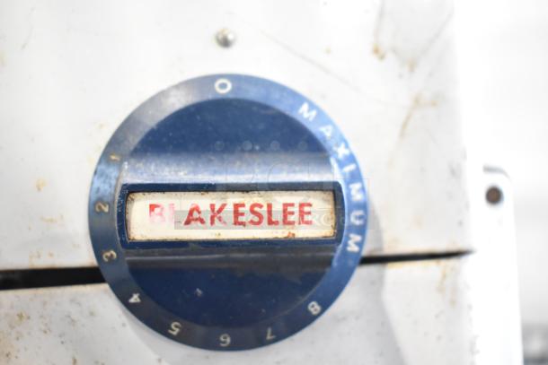 Blakeslee K7 metal countertop dough mixer dial, features speed settings 1-9 and "Blakeslee" label. Visible wear on surface.