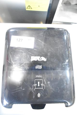 Tork black poly wall mount paper towel dispenser, visible scuffs, Tork logo, "Matic" and SCA branding, tagged with "127 QTY."