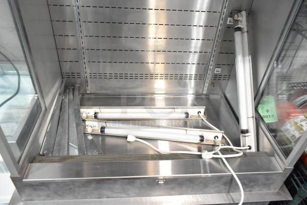 Metal commercial vertical reach-in merchandiser, 115 volts, 1 phase, stainless steel, interior lighting.