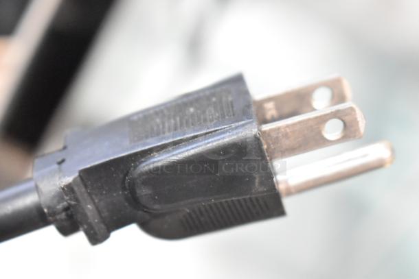 Close-up view of a standard black electrical plug for the Star 174CBA Hot Dog Broiler, showcasing prongs and cord condition.