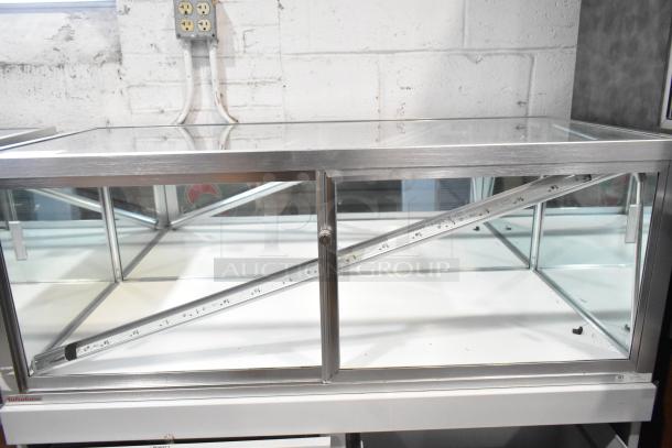 Jahabow metal commercial dry merchandise display case, glass and metal construction, good condition, visible logo at base.