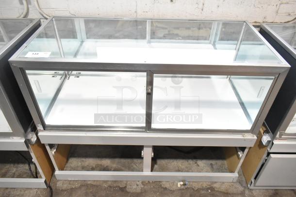 Jahabow metal commercial dry merchandise display case with glass panels, silver trim, and security lock, in good condition.