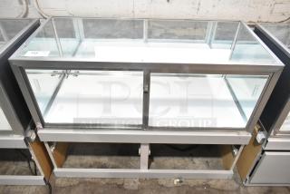 Jahabow metal commercial dry merchandise display case with glass panels, silver trim, and security lock, in good condition.