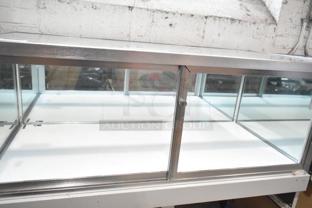 Jahabow metal commercial dry merchandise display case with glass panels and lockable doors, in good condition.
