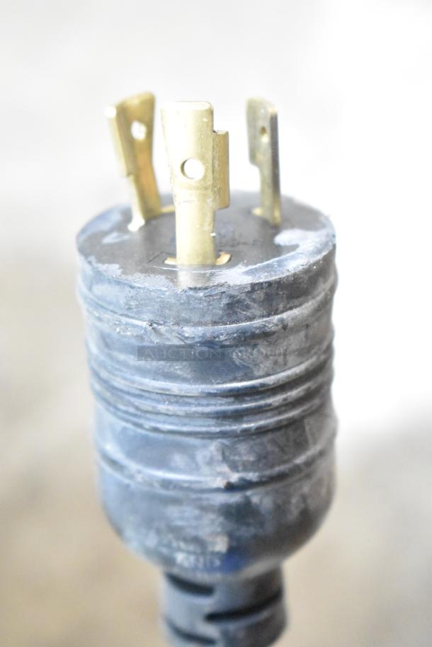 Close-up of metal plug connected to Jahabow display case. Features visible wear, essential for electrifying display.