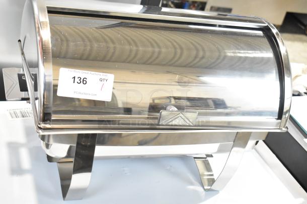 Stainless steel roll top chafer with curved lid, reflective finish, and sturdy legs. Visible label reads "136."