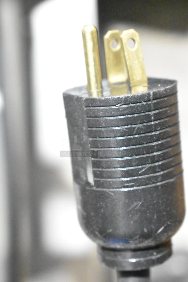 Close-up of a power plug for the JBT 2ND-GEN-MFJ-HE citrus juicer, showing prongs and cord detail.