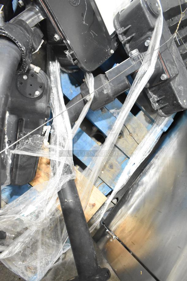 Five various metal outdoor light fixtures, wrapped in plastic. Black and silver finish, resting on a wooden pallet. Condition appears used.