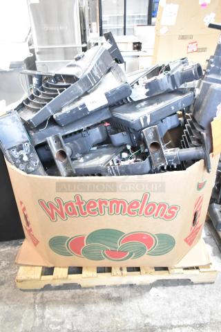 Box of 16 various metal outdoor light fixtures, including GE, showing signs of wear, in a cardboard watermelon box on a pallet.
