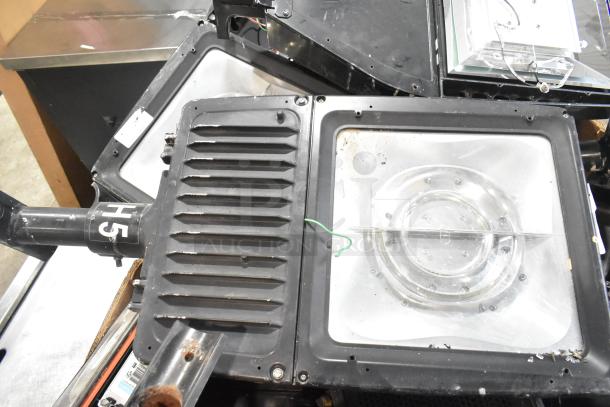 16 metal outdoor light fixtures including GE, used, varying styles, some with labels, ideal for exterior lighting projects.