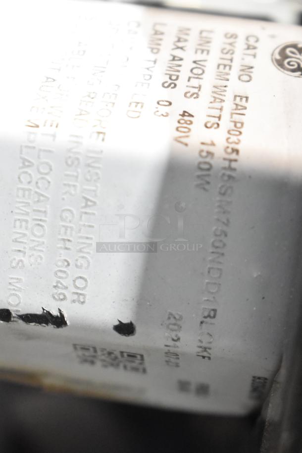 GE metal outdoor light fixture label, model EALP035H6SM, 150W, 480V, LED lamp type, shows system specs and safety info.