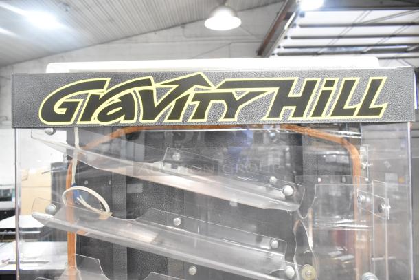Gravity Hill Metal Floor Style Arcade Game, plastic ramps, visible wiring, black and yellow logo. Appears in used condition.