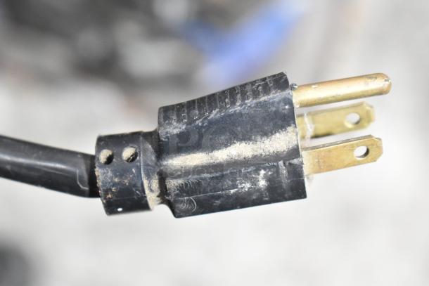 Close-up view of a worn electrical plug with visible dust and wear, possibly part of a Gravity Hill Metal Floor Style Arcade Game.