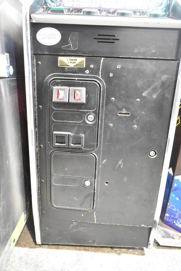 Metal floor-style slot machine, 120 volts, 1 phase, with coin slots and "1 Token 1 Play" label, showing signs of wear.