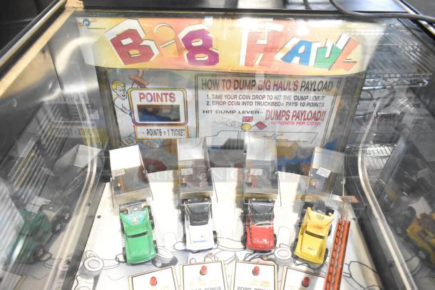 Big Haul metal arcade game, floor style, featuring miniature trucks and coin slots. Operates on 120 volts, 1 phase.