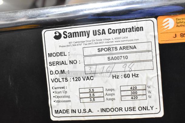 Sports Arena arcade game label showing model, serial number SA00710, 120 volts, 1 phase, made by Sammy USA Corp.