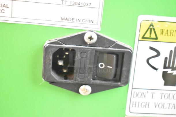 Power switch and socket on Ticket Tornado Metal Floor Style Arcade Machine with high voltage warning label.