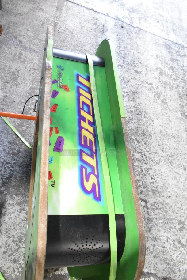 Bright green "Tickets" sign, featuring colorful ticket graphics and visible brand marking. In good condition.
