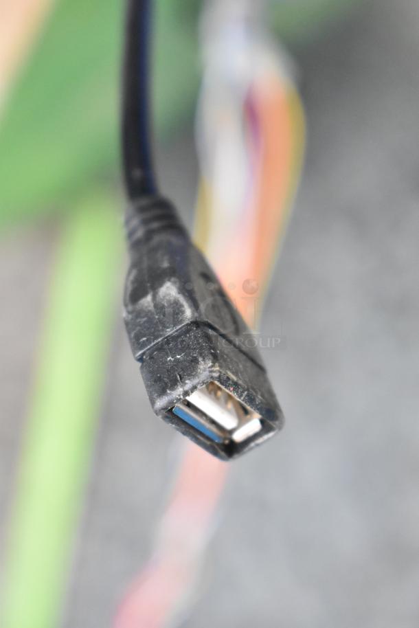 USB connector cable end, slightly worn with multicolored wires visible in background.