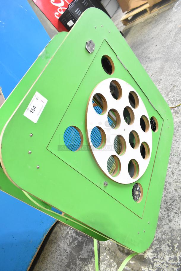 Green tickets sign with circular pattern, cutouts, and visible label "154 QT717." Slight wear on edges.