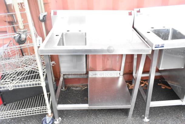 Stainless steel commercial single bay sink with backsplash and under shelf, sturdy construction, excellent condition.
