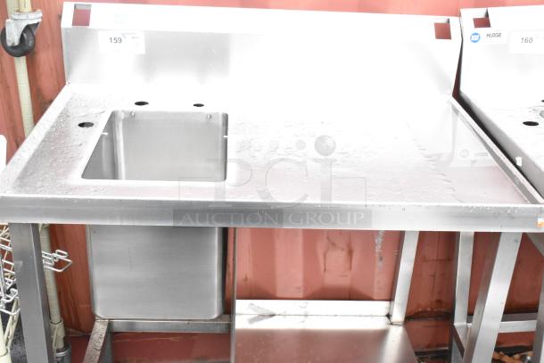 Stainless steel commercial single bay sink with backsplash and under shelf, in good condition. Features label with NSF marking.