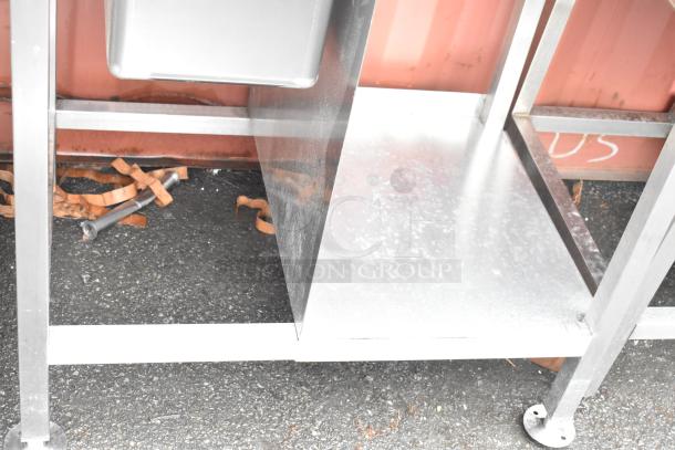 Stainless steel commercial single bay sink with backsplash and under shelf, polished finish, sturdy construction, new condition.