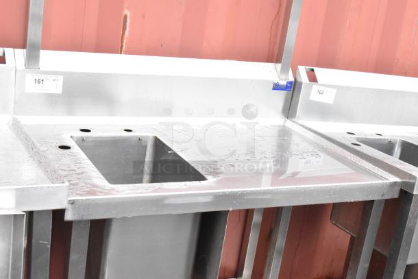 Stainless steel commercial single bay sink with backsplash, undershelf, faucet holes, in good condition, label "161 QTY 1".