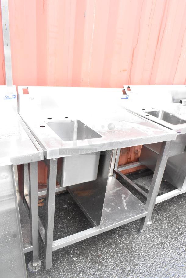 Stainless steel single bay sink with backsplash and undershelf. Features label "162." Ideal for commercial use.