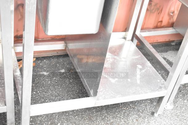 Stainless steel commercial single bay sink with back splash and under shelf, shown in good condition.