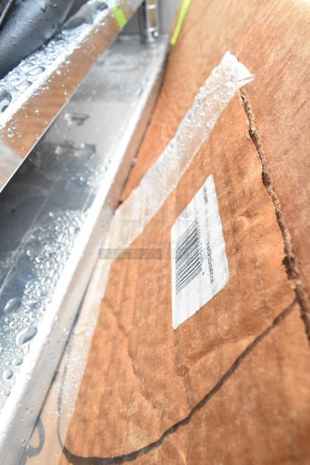 Cardboard packaging with visible barcode label "922KDC14183", adjacent to a wet metal surface.