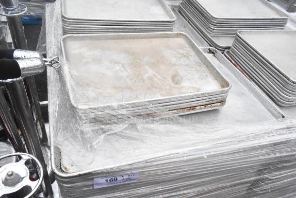 Stack of 392 metal baking pans, full and half sizes (18x26x1, 13x18x1), visible wear, auction item 169.