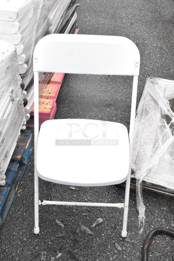 52 black folding chair frames and white folding chairs, stacked, good condition; 52 times your bid.