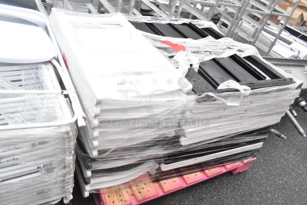 Stack of 36 black and white folding chairs wrapped for auction, in good condition, palletized for easy transport.