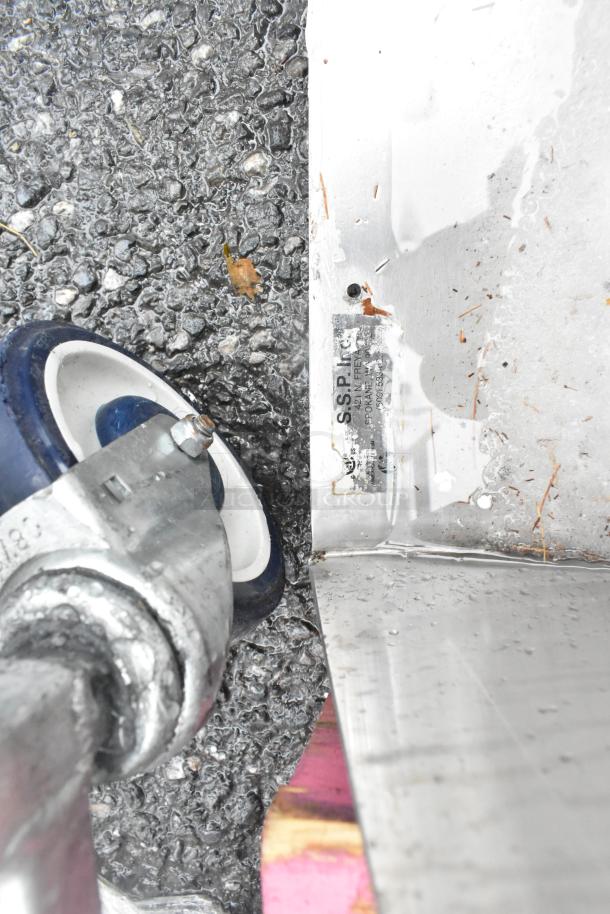 Stainless steel 3 bay sink with dual drain boards; missing one leg. Visible label shows manufacturer details.