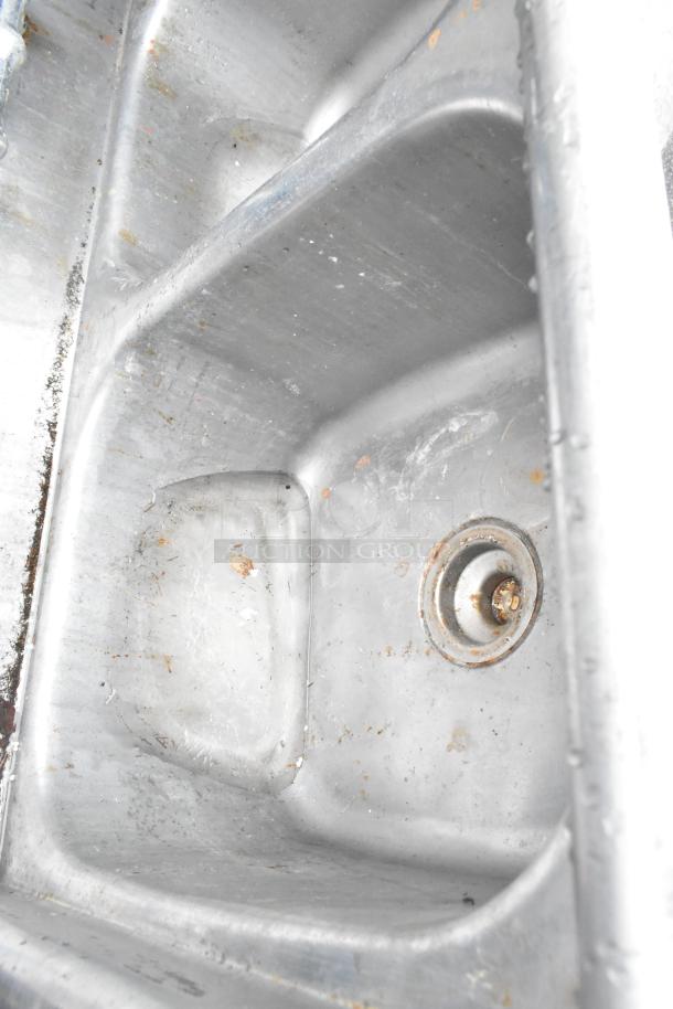 Stainless steel 3 bay sink with missing right legs, signs of wear and rust, suitable for commercial use.