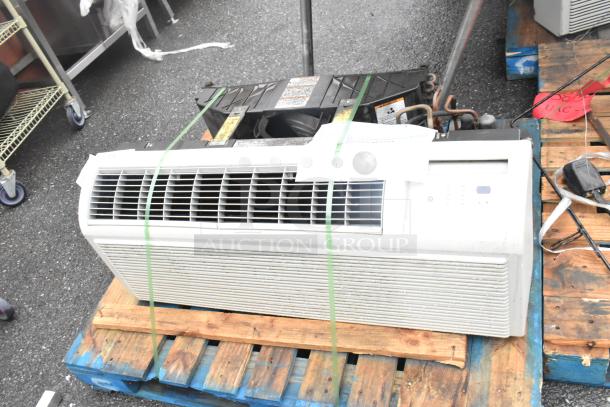 Split type air conditioner on a pallet, white color, used condition, visible control panel and vents, secured with straps.