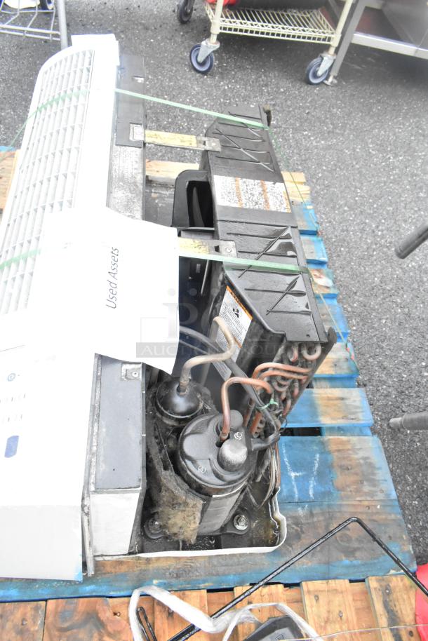 Split type air conditioner on a pallet, showing exposed internal components. Labeled "Used Assets," indicating condition.