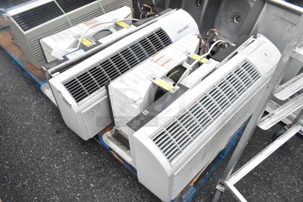 Two metal air conditioners on a pallet, labeled "Used Asset," showing signs of wear.
