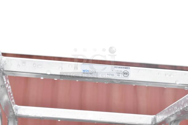 Winholt metal commercial pan transport rack with NSF label and model number AI-1210-WM. Features commercial casters.